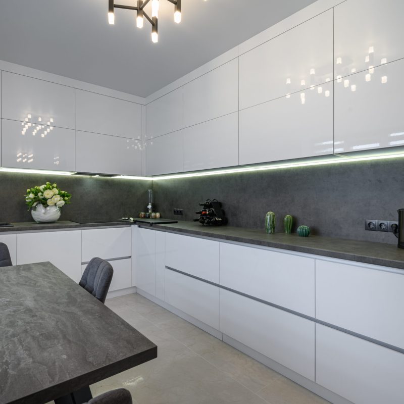 Luxurious modern trendy white and grey kitchen interior after renovation, with granite counter top